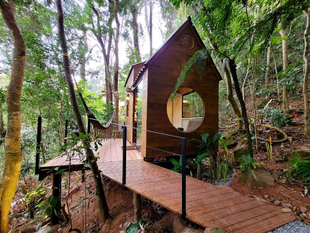 domek na drzewie w lesie z drewnianym tarasem w obiekcie Tiny House da serra perto de São Paulo em meio a natureza w mieście Mairiporã