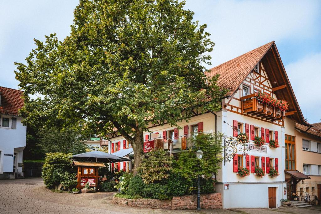 un bâtiment avec un arbre en face dans l'établissement Landgasthaus zur Linde, à Buhl