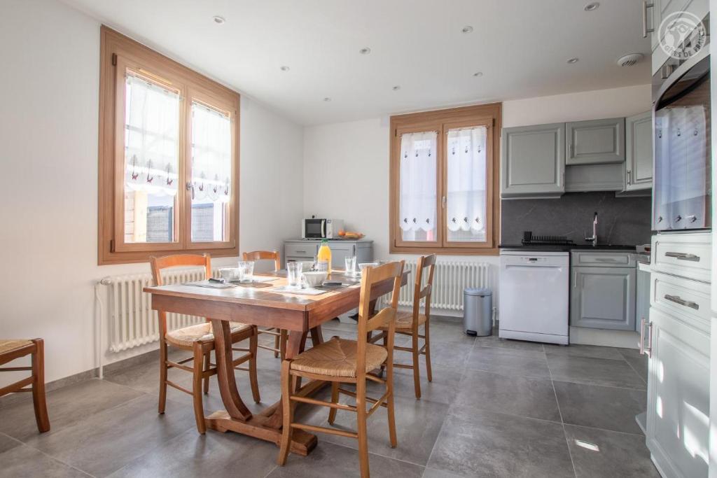 a kitchen with a wooden table and chairs at Chez nicole et alain in Ugine