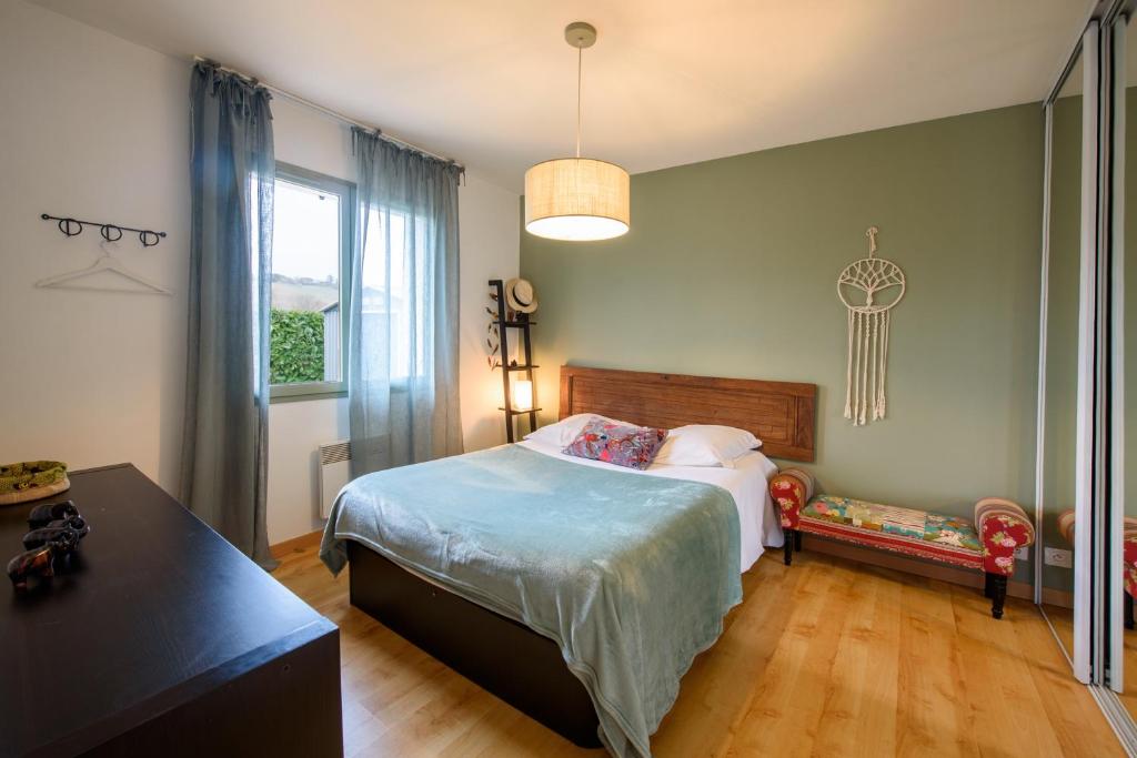 a bedroom with a bed and a table and a window at L&#39;Orinss - Maison avec jacuzzi in Saint-Orens-de-Gameville