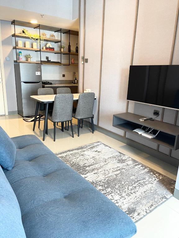 a living room with a blue couch and a table at 2 BR I ANDERSON I 18floor I above pakuwon mall I the biggest shopping center in Surabaya