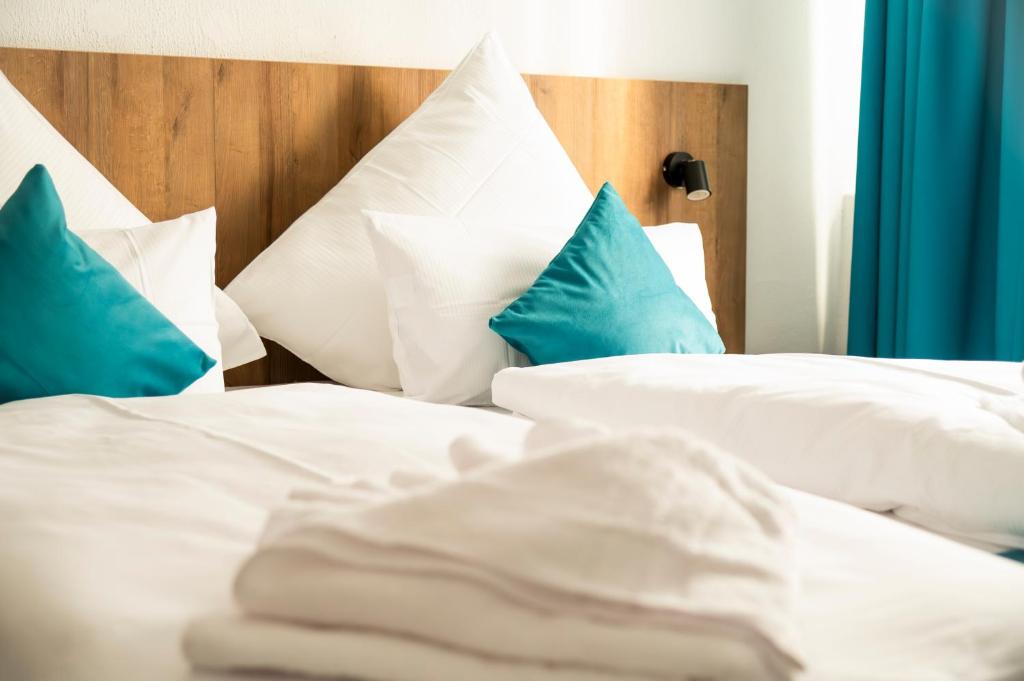 斯圖加特的住宿－Hotel Hansa Stuttgart City，一间卧室配有两张带蓝白色枕头的床
