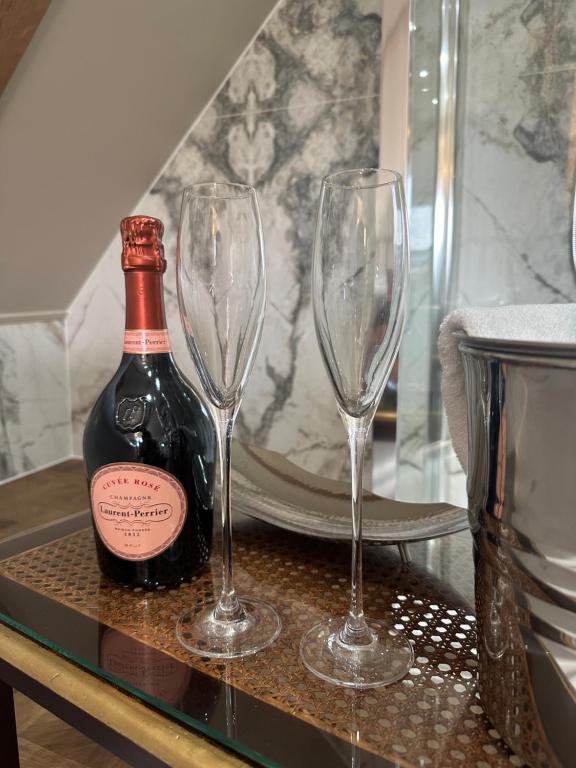 a bottle of wine and two wine glasses on a table at Old Town House by Ezestays in Margate