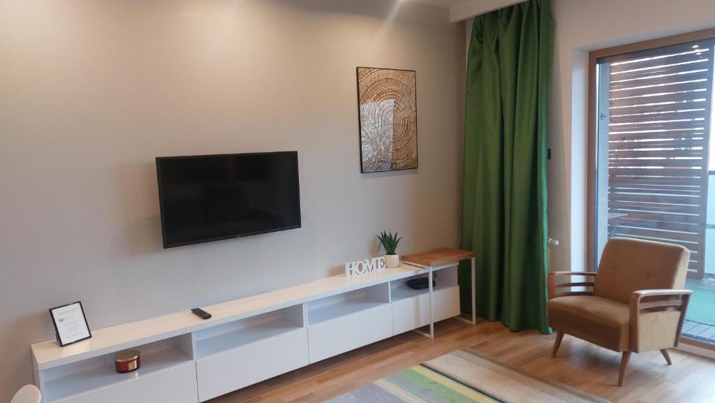 Televízia a/alebo spoločenská miestnosť v ubytovaní Apartament Robinia z miejscem parkingowym