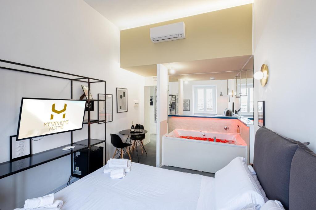 um quarto com uma cama e uma casa de banho com uma banheira em MyTinyHome Fastime em Roma
