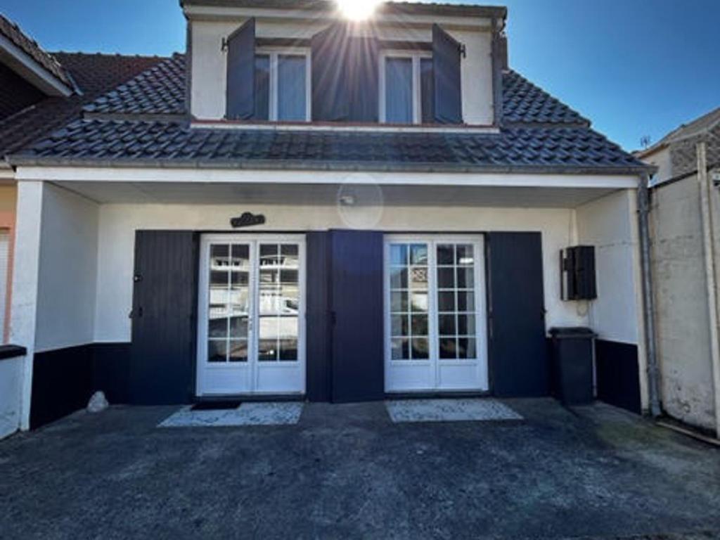 una casa azul y blanca con dos puertas en Villa Quend, 4 pièces, 6 personnes - FR-1-730-6 en Quend