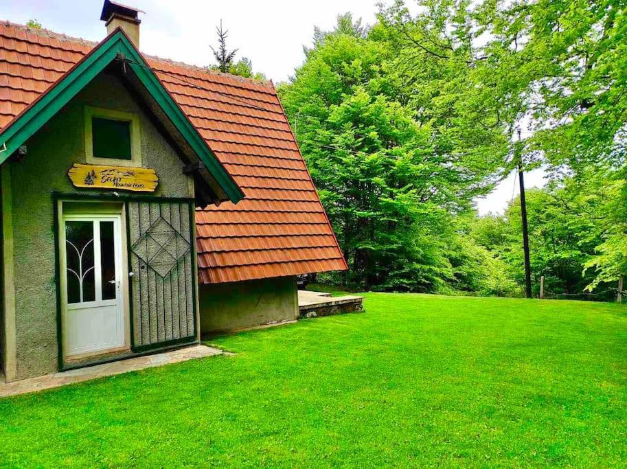 a small house with a green yard with a door at Woodland Cosy ‘Secret’ Villa in the beauty Osogovo Mountain in Lesnovo