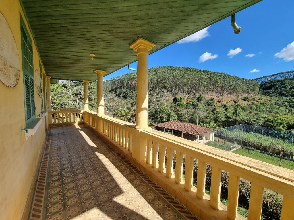 un balcón de una casa con vistas a la montaña en Fazenda Itamirim - Chácara para alugar com piscina, campo de futebol, churrasqueira e salão de festas - Próximo a São José dos Campos e ao Mobai Bike, en Jacareí