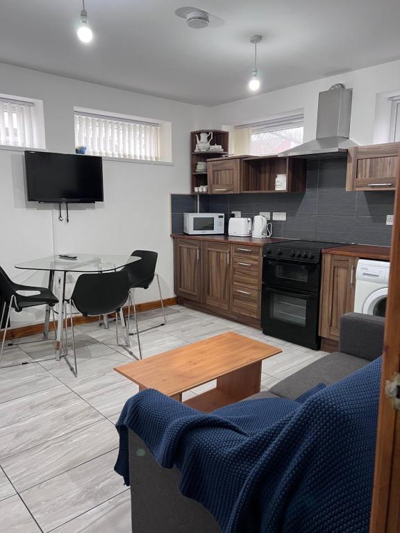 a living room with a table and a kitchen at Luxury 2 Bed Apartment at Seymour grove in Manchester