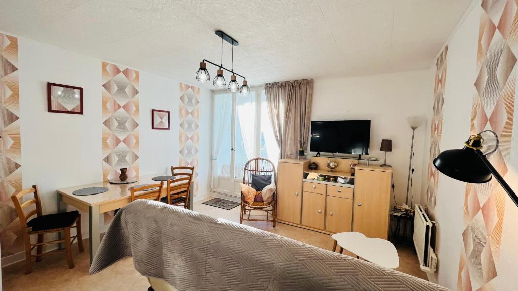 une chambre avec un lit, un bureau et une télévision dans l'établissement Les Joncs, T2 lumière et mer, à Saint-Hilaire-de-Riez