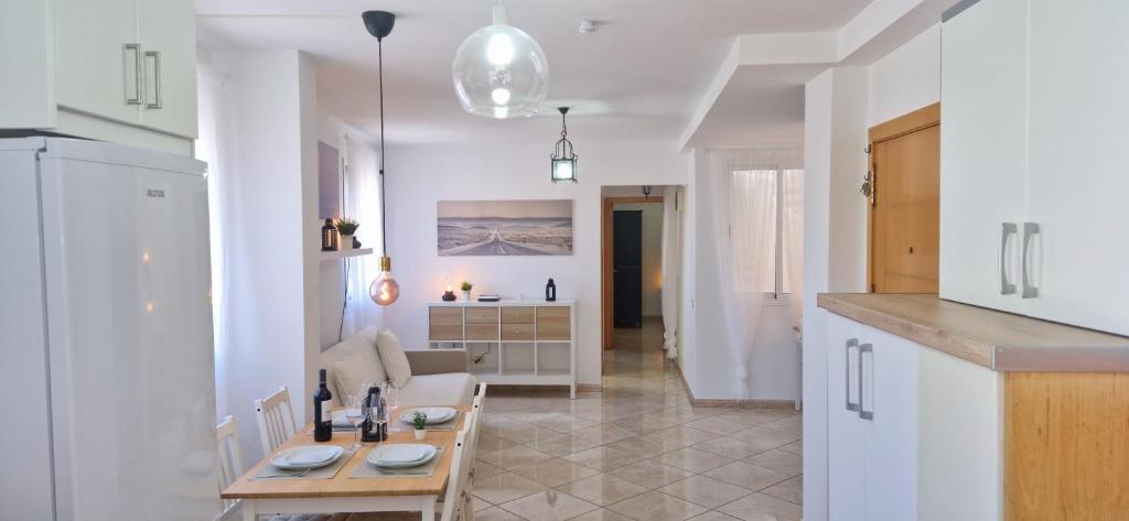 a kitchen and living room with a table and a couch at Vivienda vacacional a 10 minutos de la capital. in Arucas