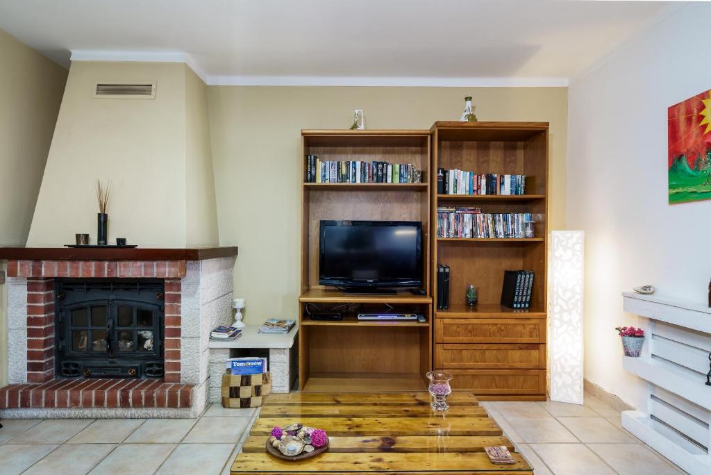 sala de estar con TV y chimenea en Apartment in a House, en Tavira