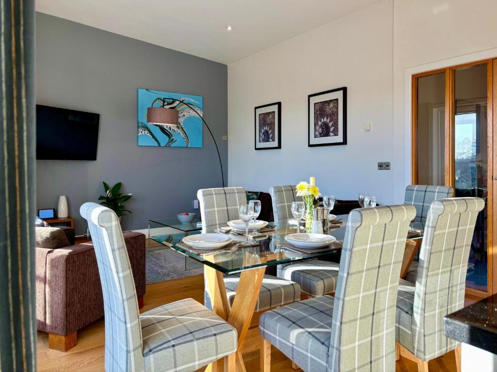 comedor con mesa de cristal y sillas en Your Space Apartments – Hamiltons, en Cambridge