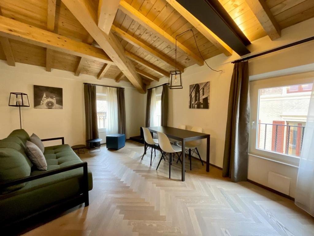 een woonkamer met een bank en een tafel bij Saragozza Suite 7 Attico con altana a due passi da Piazza Grande WIFI e parcheggio gratuito in Modena