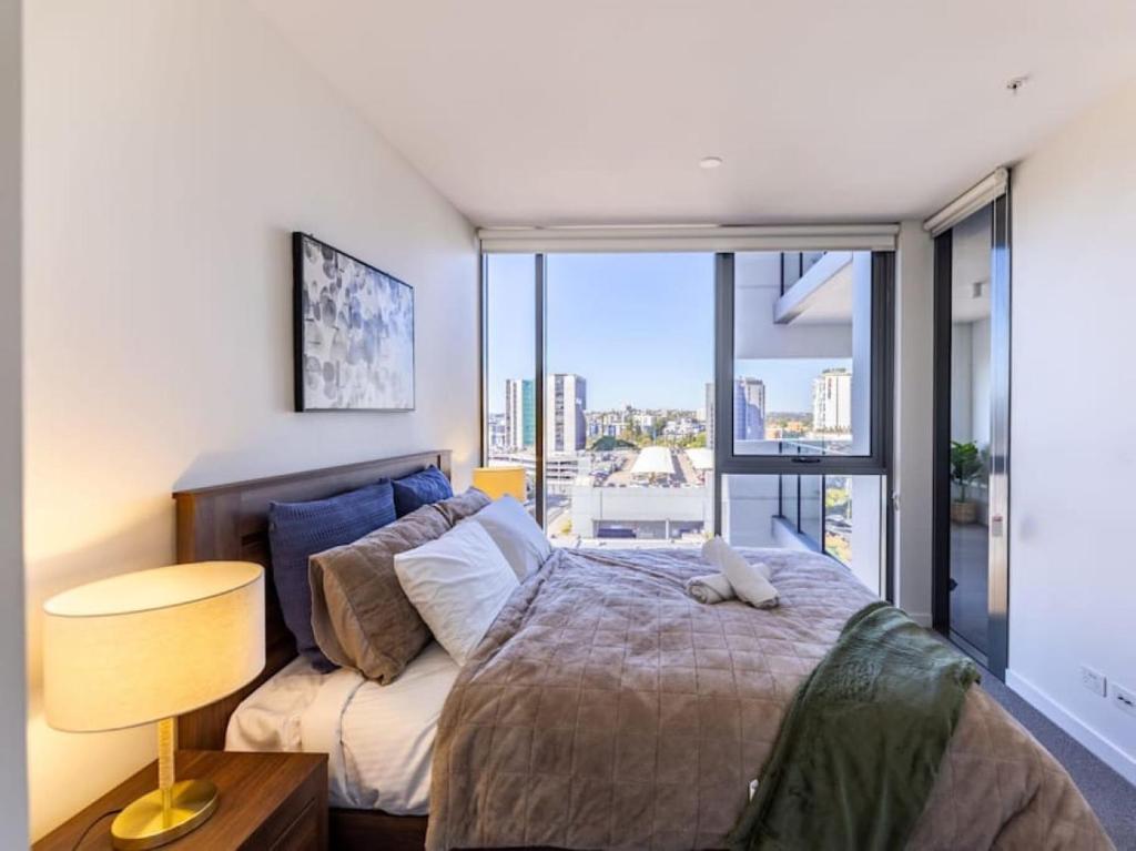 ein Schlafzimmer mit einem Bett und einem großen Fenster in der Unterkunft Toowong Central Carpark and Wifi Great value 1BR Apt in Brisbane