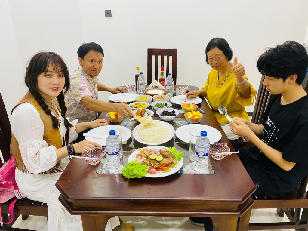 grupa ludzi siedzących przy stole jedzących jedzenie w obiekcie Udara Guest - Yala Safari w mieście Yala
