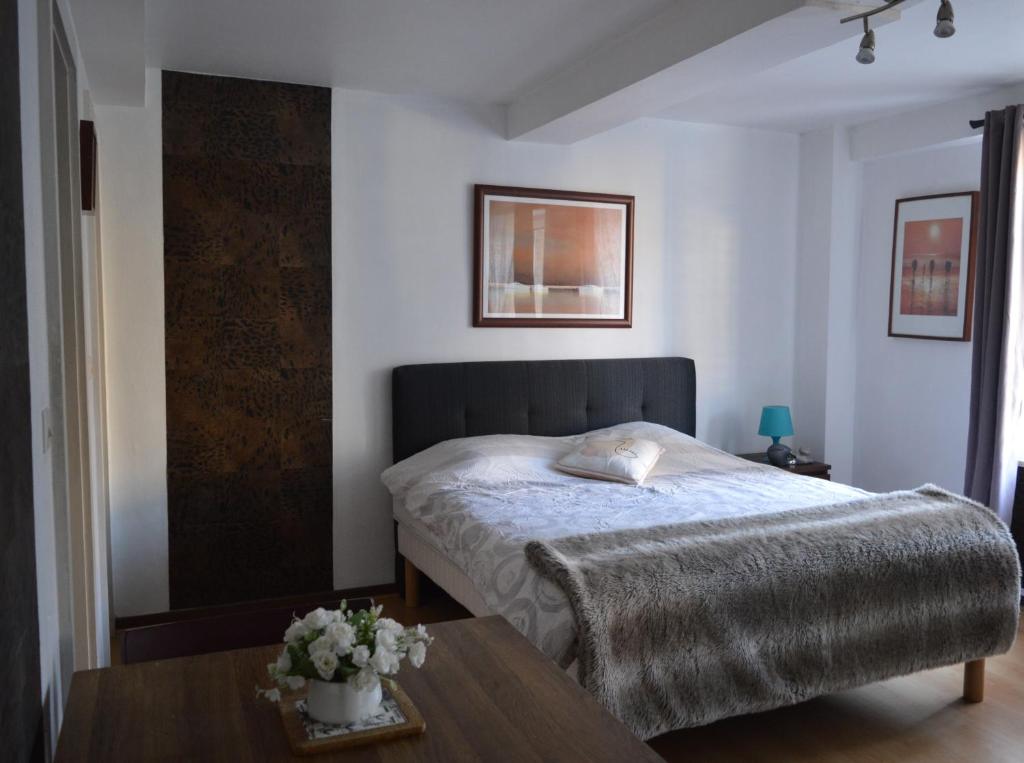 - une chambre avec un lit et une table en bois dans l'établissement Studio Mohange, à Morhange