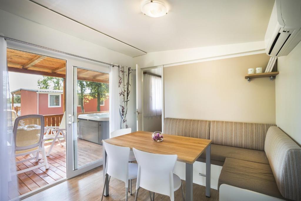 a dining room with a table and white chairs at Maistra Camping Valkanela Mobile homes in Funtana