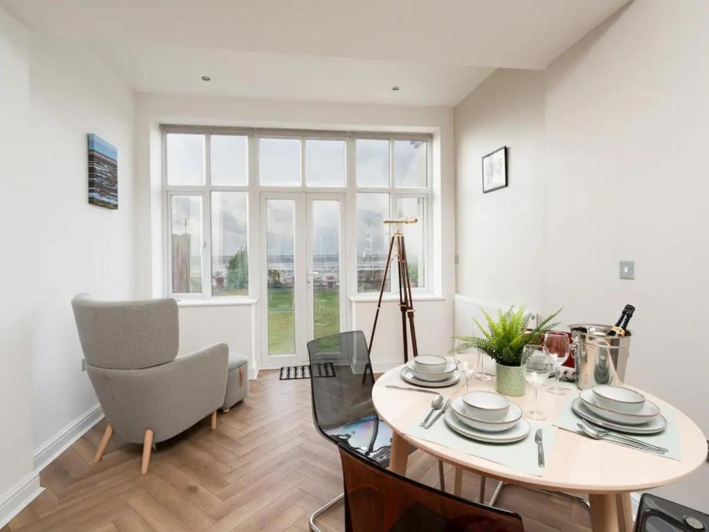 a dining room with a table and a large window at Pass the Keys Golfers Haven 2 BD Flat on Hoylake Beach Parking in Hoylake