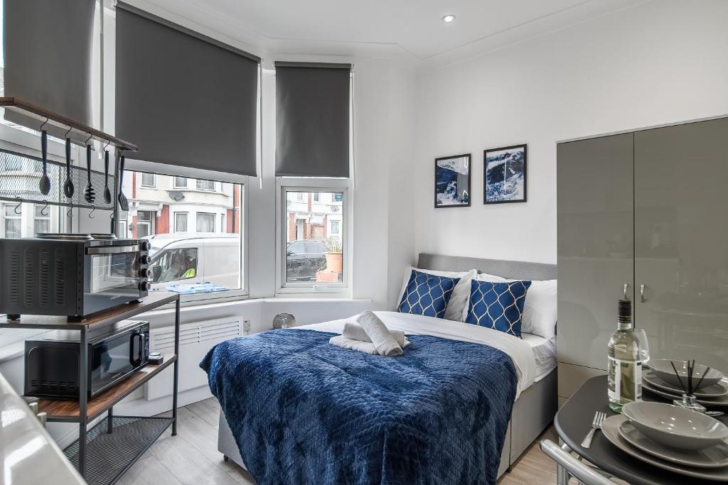a bedroom with a bed with a blue blanket at Modern Studio Rooms in Zone 2 London in London