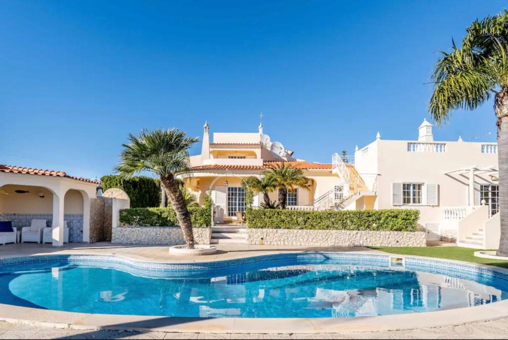 eine Villa mit einem Swimmingpool vor einem Haus in der Unterkunft Villa Paraíso in Poço Partido