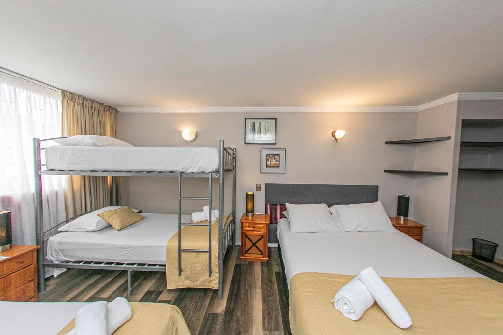 a bedroom with two bunk beds and a window at Hotel Murano in Concepción