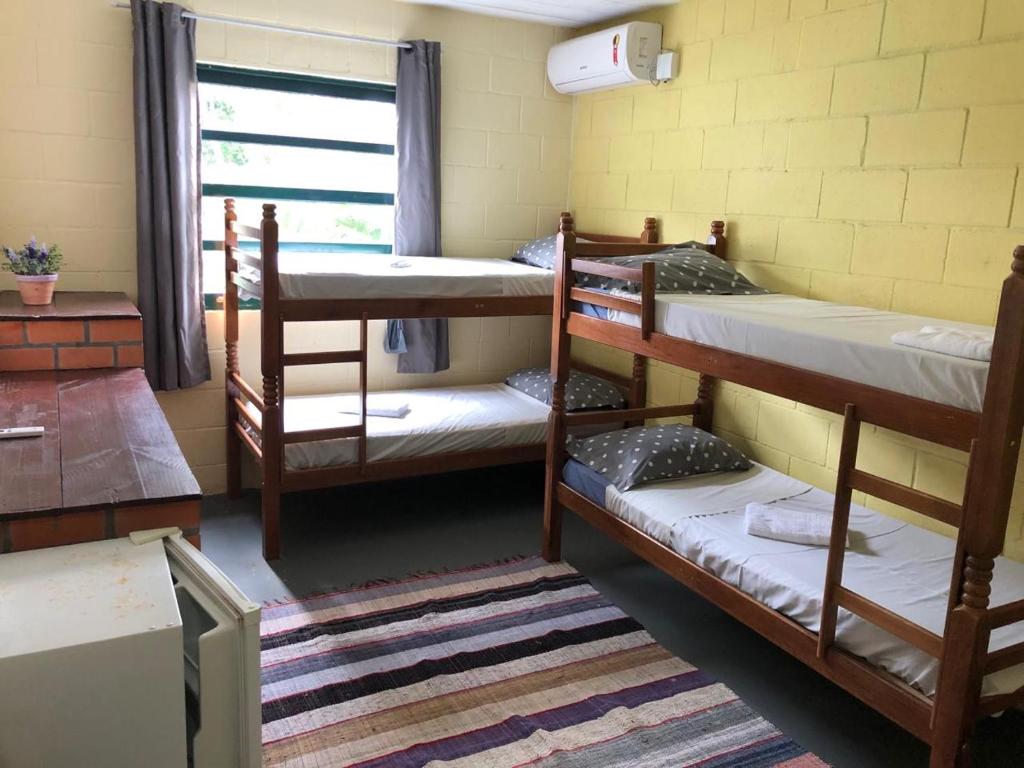 um quarto com 3 beliches e uma janela em Pousada Girassois Hostel em Florianópolis