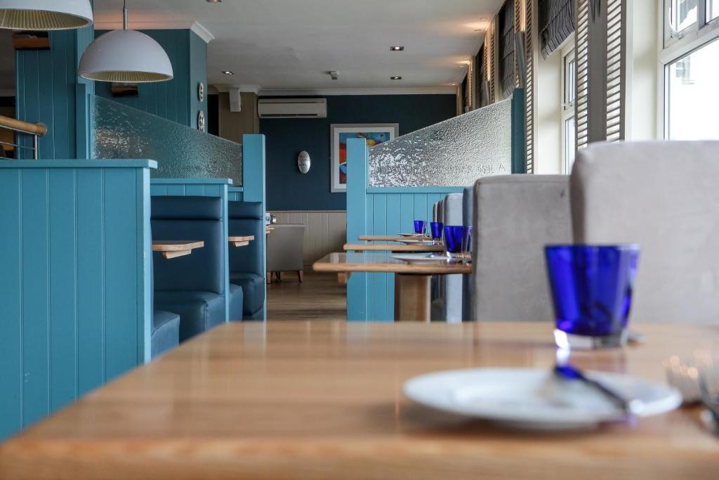 a dining room with blue walls and a table with a plate at The Brudenell in Aldeburgh