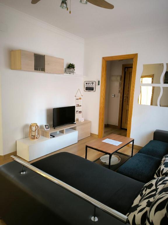 ein Wohnzimmer mit einem Sofa und einem Tisch in der Unterkunft La casita de Lyra in Granada