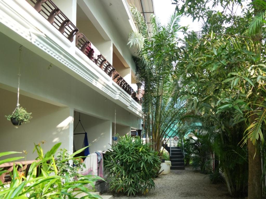 a courtyard of a building with trees and plants at Mad about Coco Yoga & Beach Retreat in Varkala