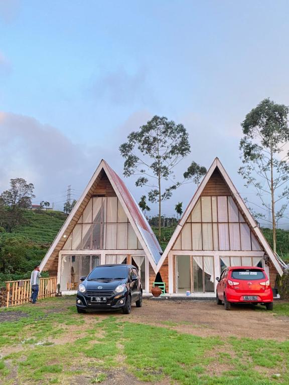 zwei Autos, die vor einem Haus geparkt sind in der Unterkunft Alas Tegal villa cabin syariah in Wonosobo