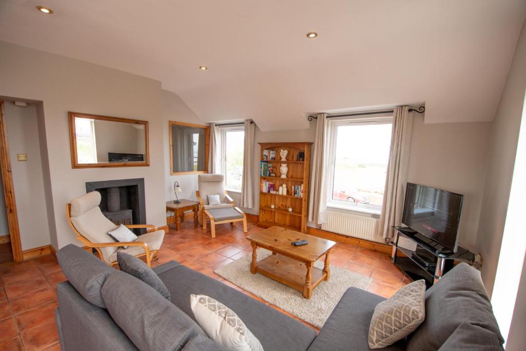 a living room with a couch and a tv at 3 Fishery Cottages - 2 Bedroom house close to town in Bundoran