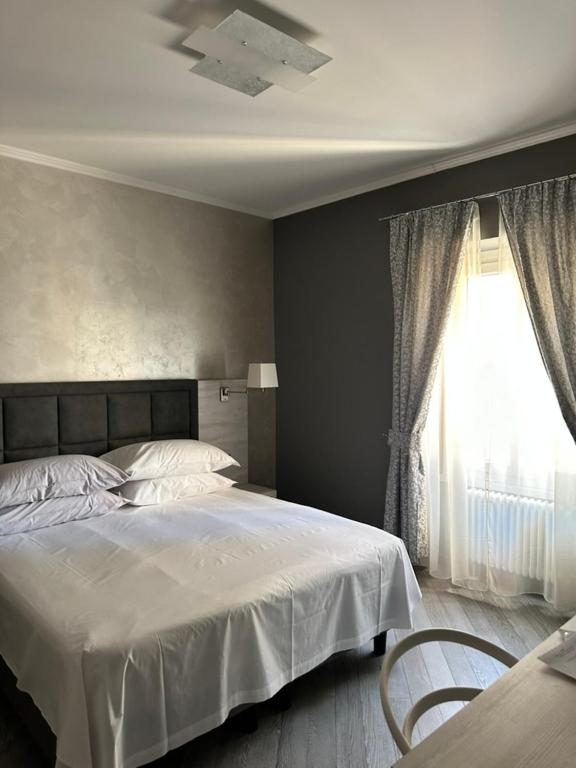 Hotel PRIMA FILA Premium Guest House, a bedroom with a white bed and a window at PRIMA FILA Premium Guest House in Sanremo