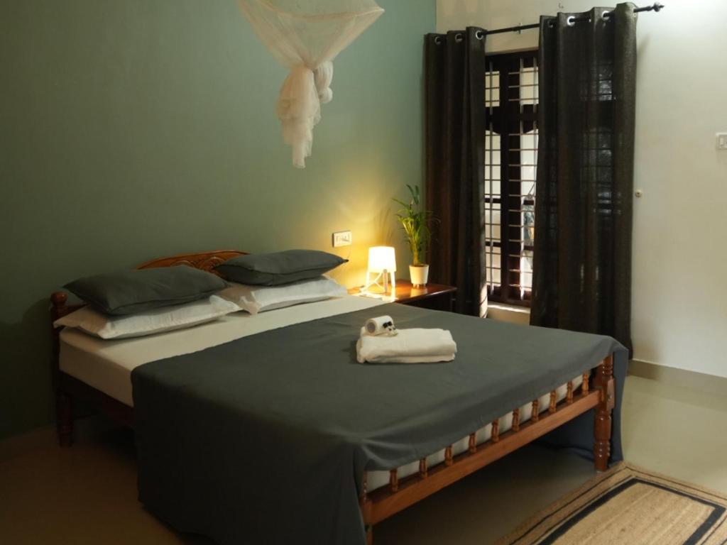 a bedroom with a bed with a towel on it at Mad about Coco Yoga & Beach Retreat in Varkala