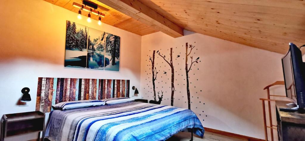 Schlafzimmer mit einem Bett und einem TV in der Unterkunft Trilocale mansardato nel cuore della Val Di Fiemme in Ziano di Fiemme