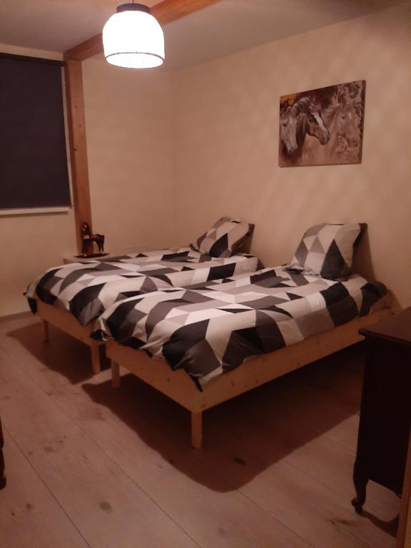 une chambre avec un lit avec une couette noire et blanche dans l'établissement Appartement au coeur des vignes, à Scherwiller