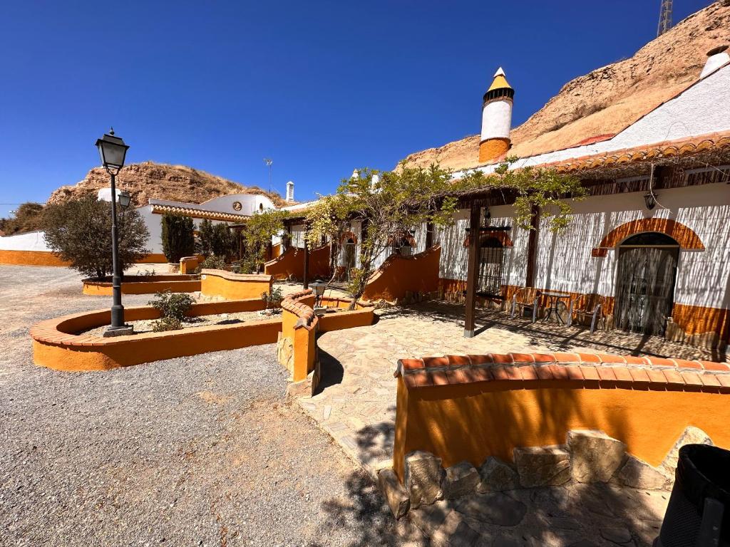 un patio de un edificio con bancos y luz de la calle en Cuevas La Granja, en Benalúa de Guadix