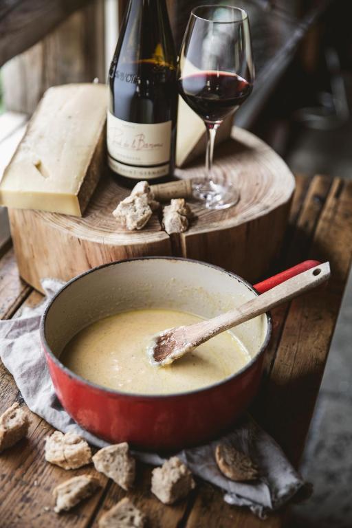 a bowl of soup and a bottle of wine and a glass at Les Fermes de Marie in Megève
