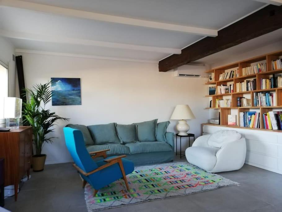 a living room with a blue couch and a chair at Charmante maison familiale vue sur mer in Marseille