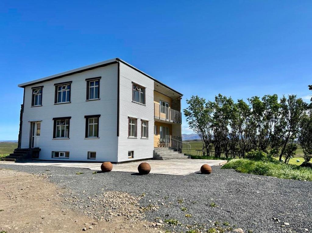 Una gran casa blanca con unas pelotas delante. en Syðri-Þverá, en Hvammstangi