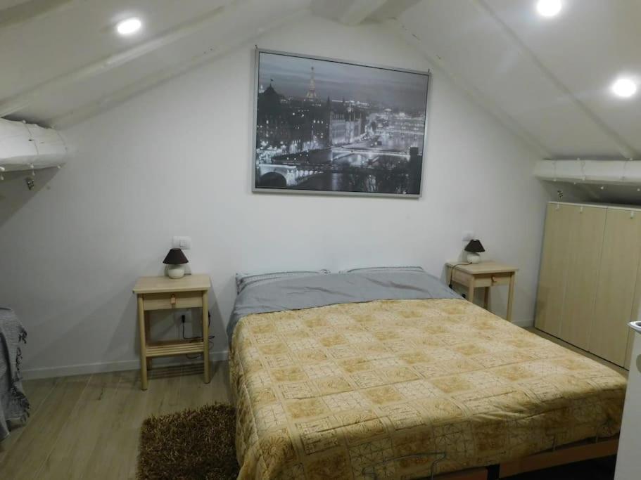 een slaapkamer met een bed en een foto aan de muur bij Maison Mirt in Bologna