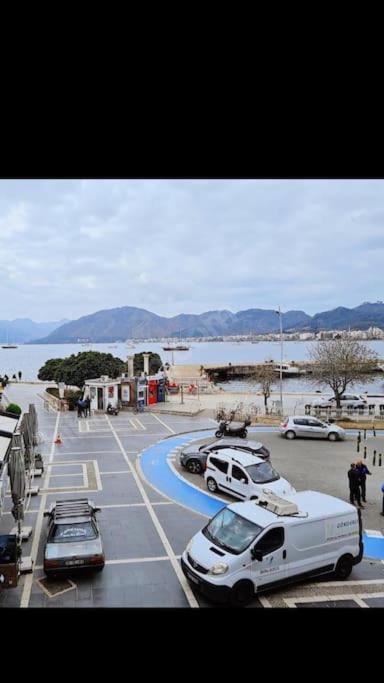 a parking lot with cars parked next to the water at Castle81homes Red, sea view central flat in Marmaris