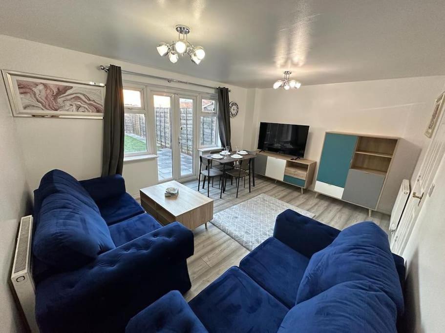 a living room with a blue couch and a table at Spacious & Lovely 4 Bedroom Home in Manchester in Manchester