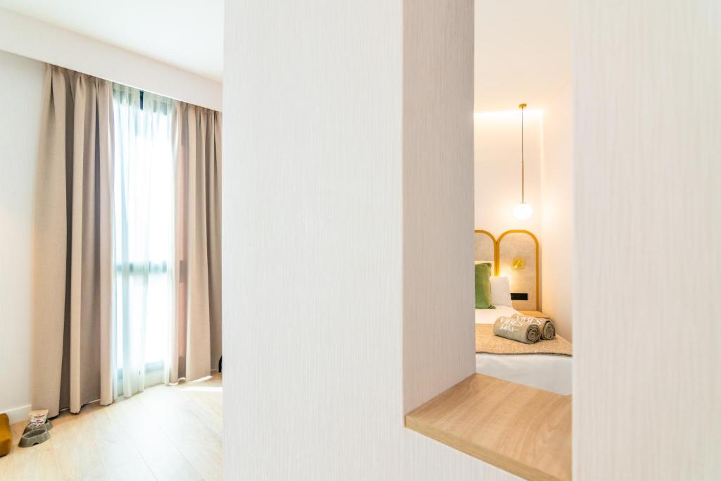 a view of a bedroom with a bed and a mirror at Hotel Málaga Vibes in Málaga