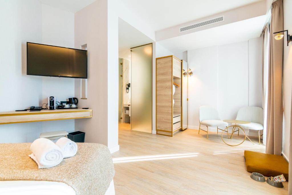 a hotel room with a bedroom with a bed and a tv at Hotel Málaga Vibes in Málaga