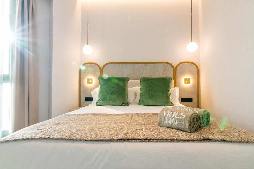 a bedroom with a large bed with green pillows at Hotel Málaga Vibes in Málaga