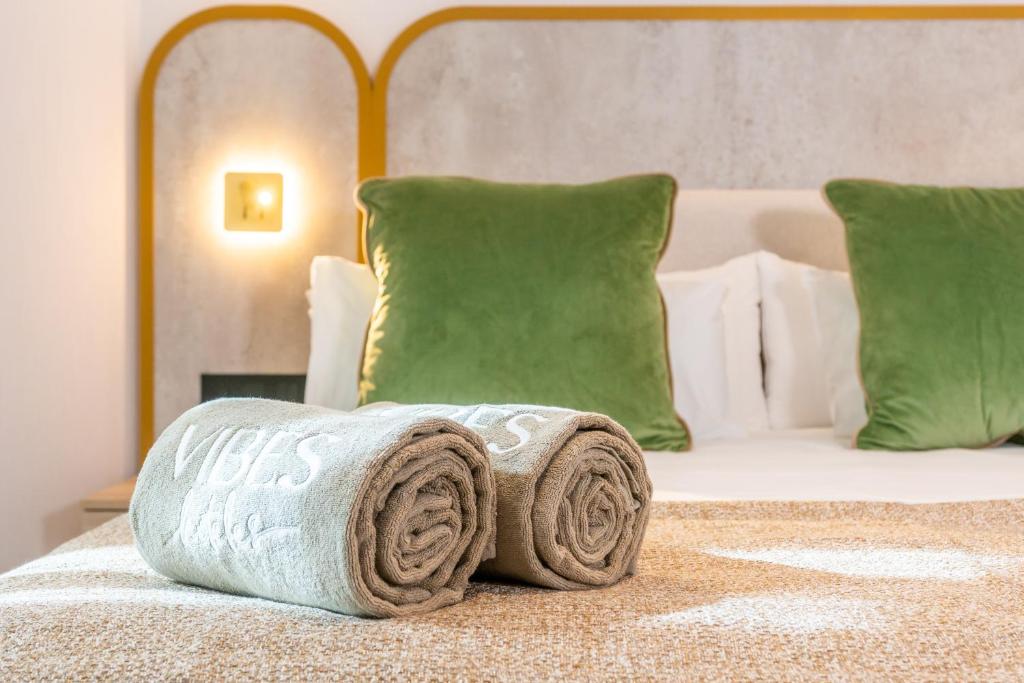 a pile of towels sitting on top of a bed at Hotel Málaga Vibes in Málaga