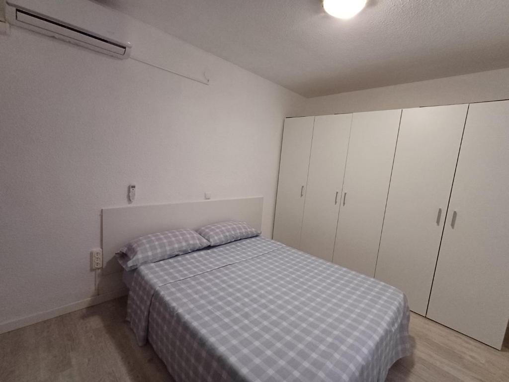 a bedroom with a bed and white cabinets at Estudio sin cocina en Benidorm in Benidorm