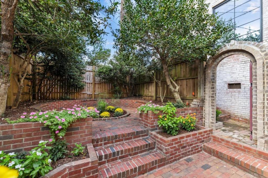 a brick garden with an arch and some flowers at Slice of Seclusion in Downtown Southern Pines in Southern Pines