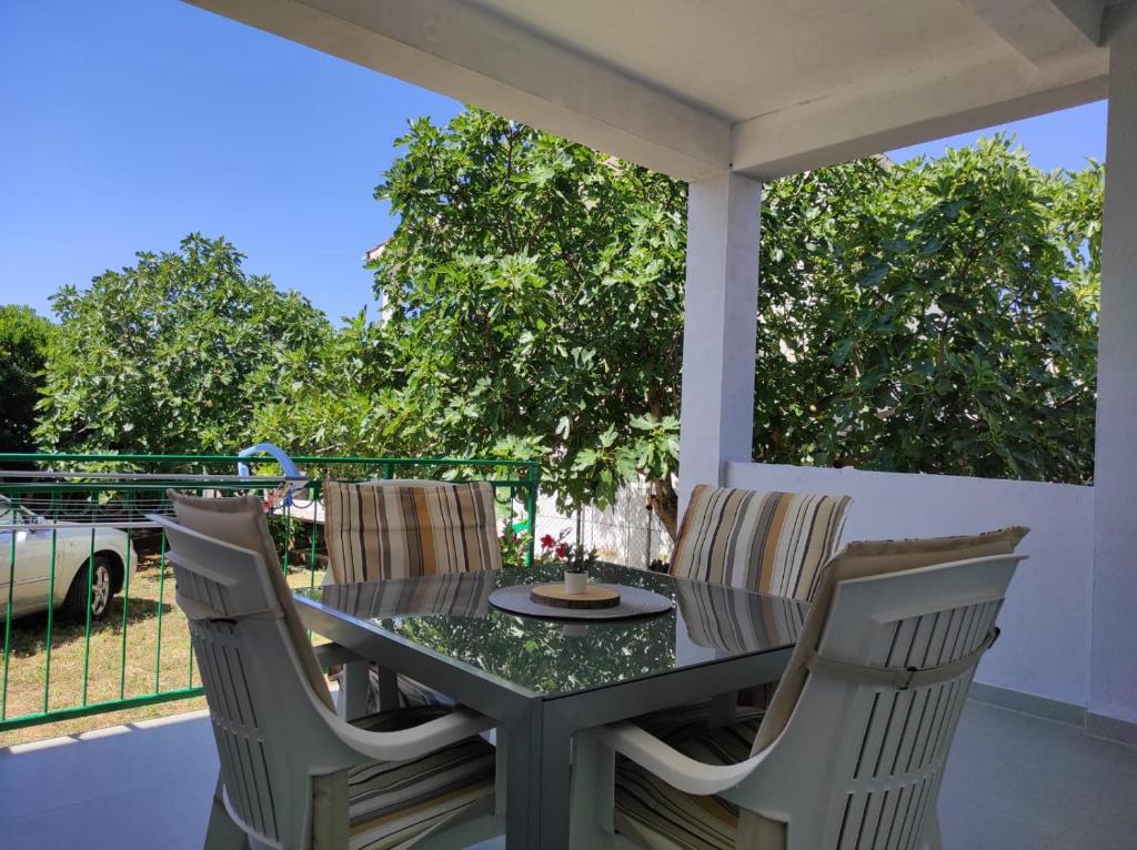 a table and chairs on a patio with a view at Apartment with Terrace and Garden in Pirovac